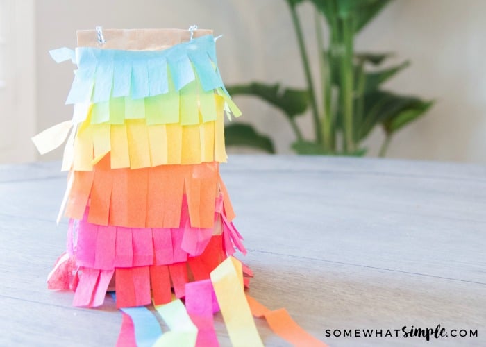 a paper bag pinata made with blue, green, yellow, orange, purple and red paper