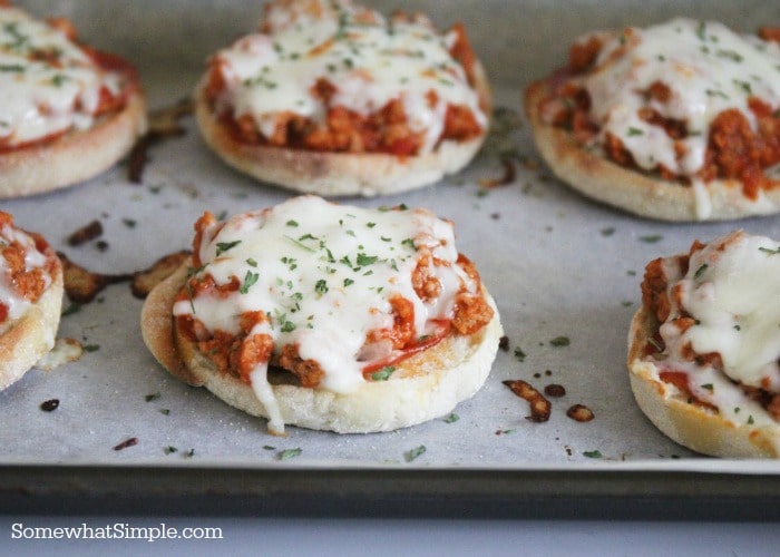 a baking sheet filled with pizza burgers fresh out of the oven