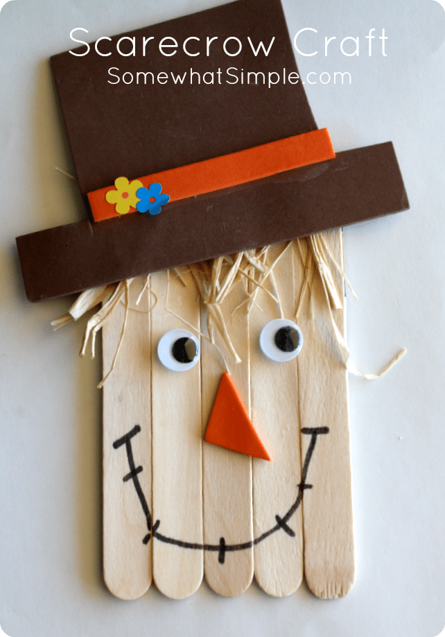 a close up of a scarecrow craft made with sticks and a brown paper hat