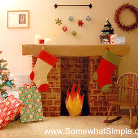 fake fireplace made with cardboard that has stockings hanging from it