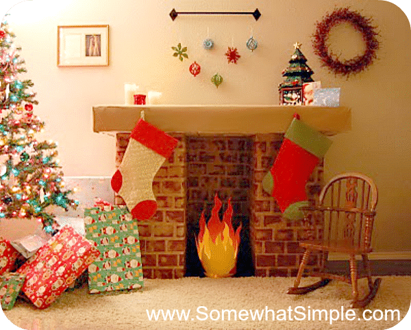 fake fireplace made with cardboard that has stockings hanging from it