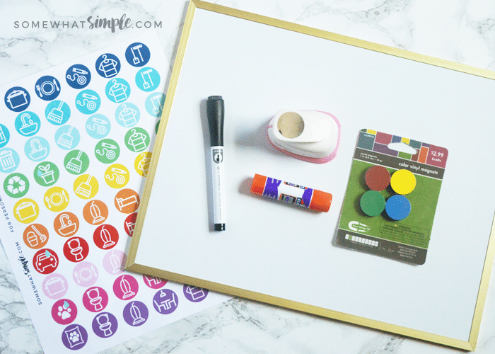 a chore magnet printable next to a magnet board, glue and a hole punch