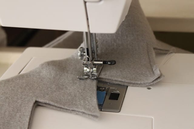 the next step in making a crown with grey felt that was previously cut out of a pattern being sewn on a sewing machine