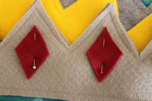 pinning the red felt diamonds to the grey felt crown outline