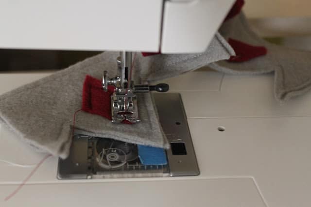 sewing the red felt diamonds to the grey felt crown