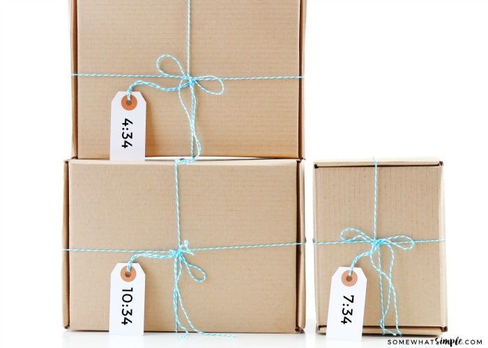 this gift idea for your husband shows three boxes wrapped in blue twine with a gift tag with different times on them tell him when to open his birthday present 