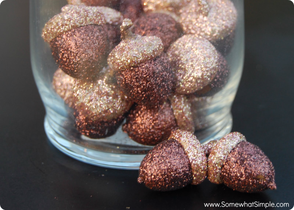 Image shows a close up of glittery acorns in a glass jar