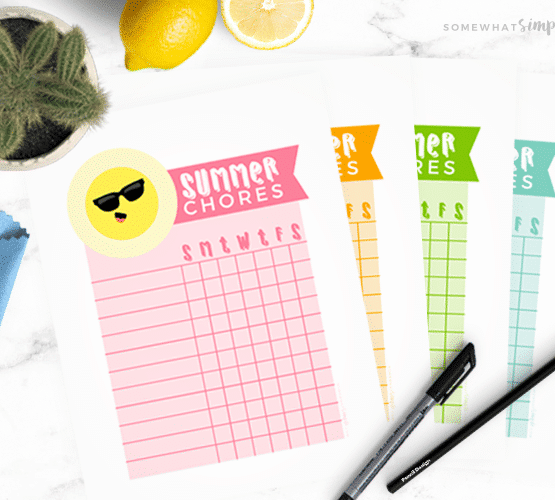summer chore charts next to some pens on a white counter