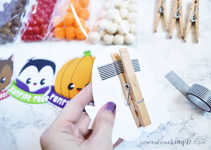 a clothes pin attached to the back of a halloween treat bag topper