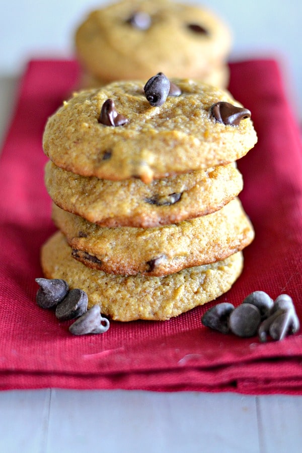 pumpkin chocolate chip cookies stacked on a red napkin