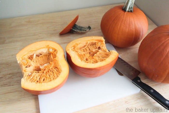 a pumpkin laying on the counter that has been cut in half.