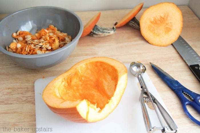 a half of a pumpkin that has the seed scooped out and are placed in a bowl behind the pumpkin