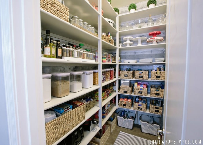 an organized kitchen pantry filled with labeled bins and other food canisters.