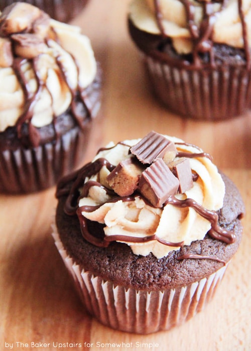 looking down on three Reese's Chocolate Peanut Butter Cupcakes topped with icing, frosting and peanut butter cup chunks