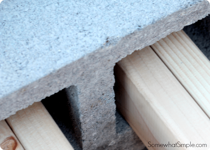 wood planks inserted into cinder blocks is a step when making a cinder block bench