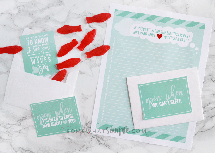 a letter with an envelope and several red swedish fish scattered on the counter