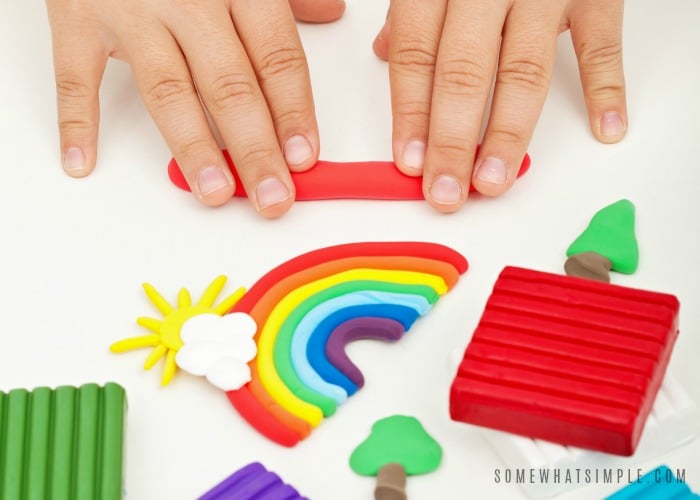 Child hands playing with colorful modeling clay