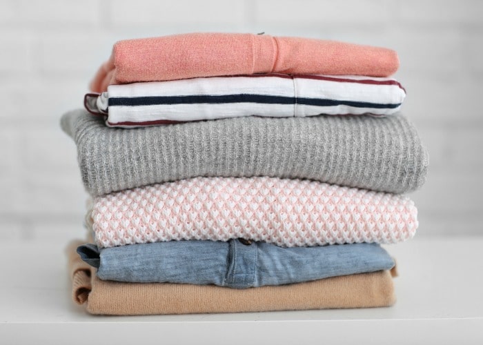 Pile of clothes on table - kids help at home with folding laundry
