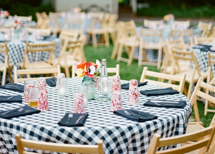 bbq wedding set up using black and white checkered table cloths and light wood chairs 