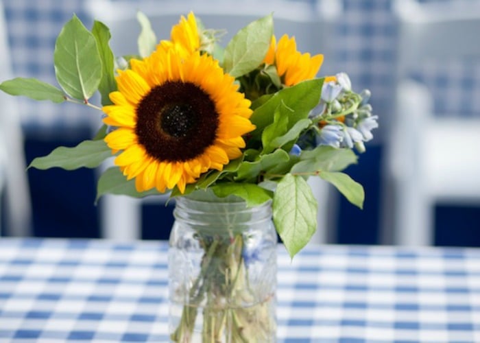 bbq party table setting with sunflowers in a mason jar