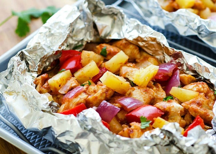 a foil dinner packed filled Grilled Chicken with onions, pineapple and bell peppers wrapped in aluminum foil is an easy camping food to make.