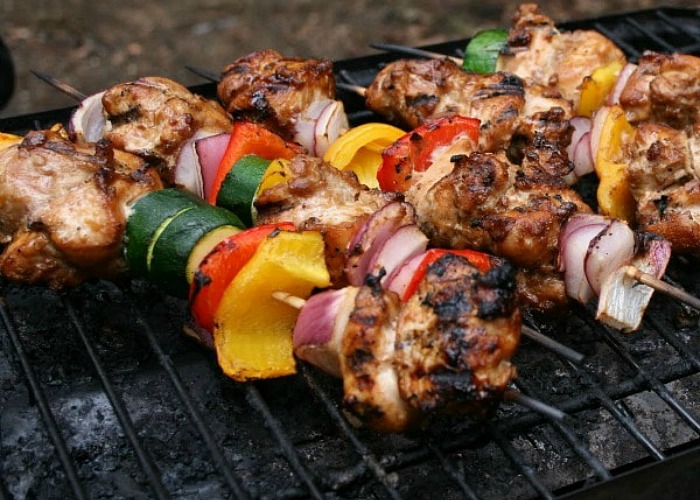 several Grilled Chicken Kabobs on a grill that are an easy dinner for camping