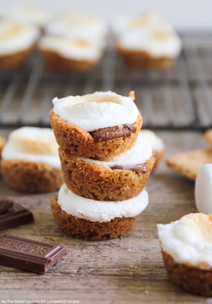 a stack of three smores bites on a counter with more of them littered around the stack