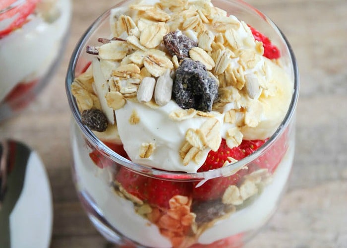 close up of a berry parfait in a glass cup