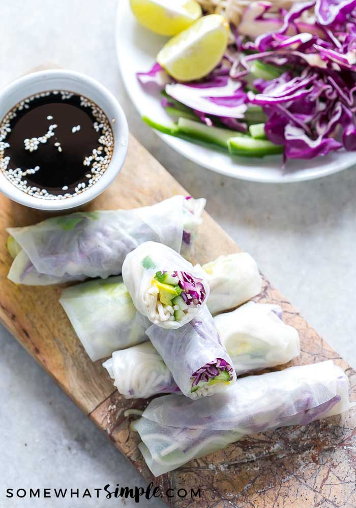 a serving tray with summer rolls and a dipping sauce