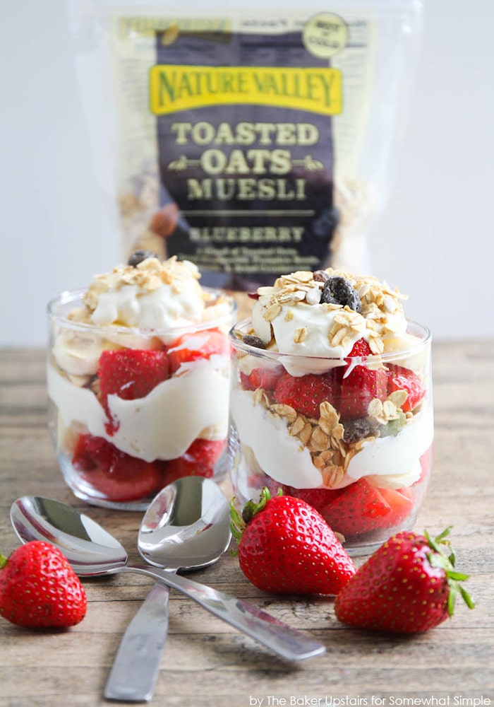 long image of two berry parfaits with granola in the background