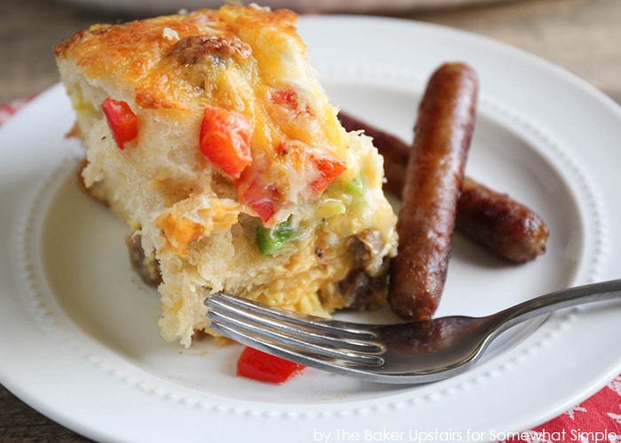 Sausage and Pepper Breakfast Biscuit Casserole on a plate with a fork and sausage links on the side