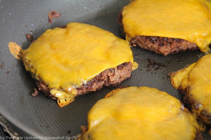 sliced cheese on top of burger patties