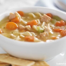 bowl of chicken noodle soup on white table cloth