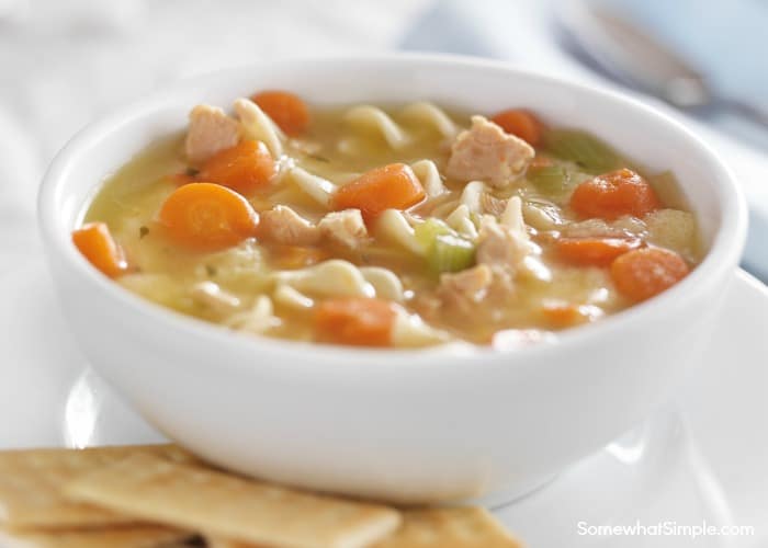 a white bowl of homemade creamy chicken noodle soup made in a crock pot using this simple recipe