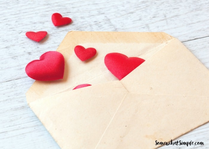 background of love letters with white wooden hearts