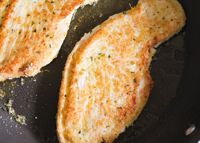 Garlic Parmesan Turkey Breast Cutlets in a frying pan cooked to a golden brown