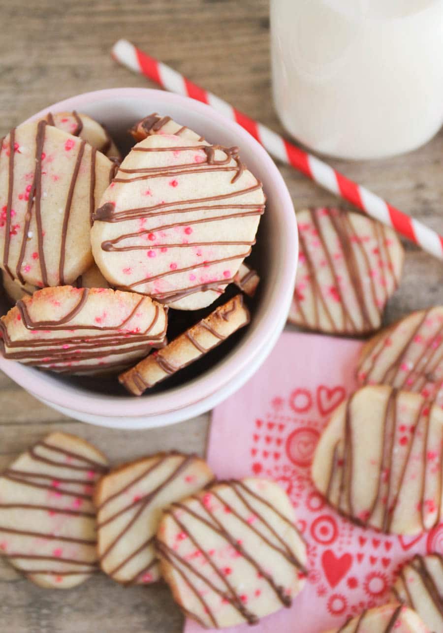Long image showing finished Valentine Shortbread Cookies in a bowl with some milk and a straw