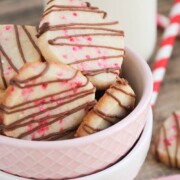 valentine shortbread cookies drizzled with chocolate in a pink bowl