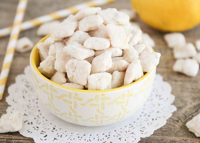 a white and yellow bowl full of lemon chex mix