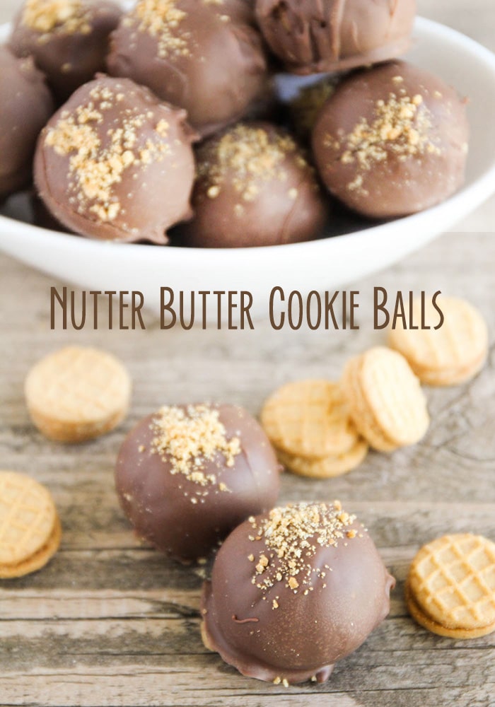 looking at a downward angle of a bowl full of Nutter Butter balls with two of the truffle balls laying on the counter next to a few small nutter butter cookies