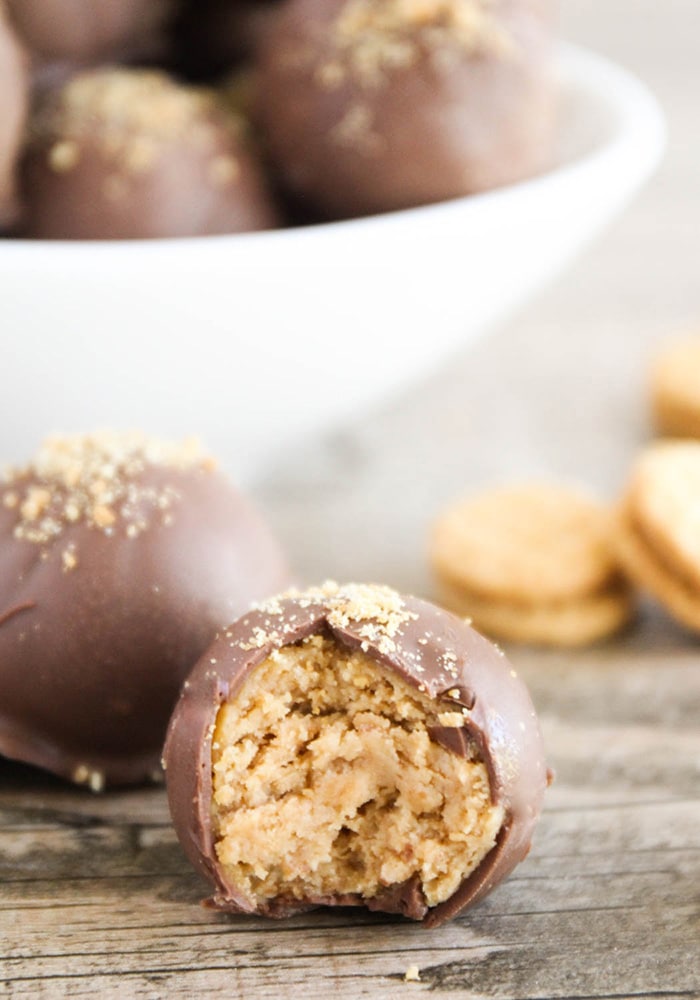 a close up of a nutter butter cookie truffle that has a bite taken out of the ball