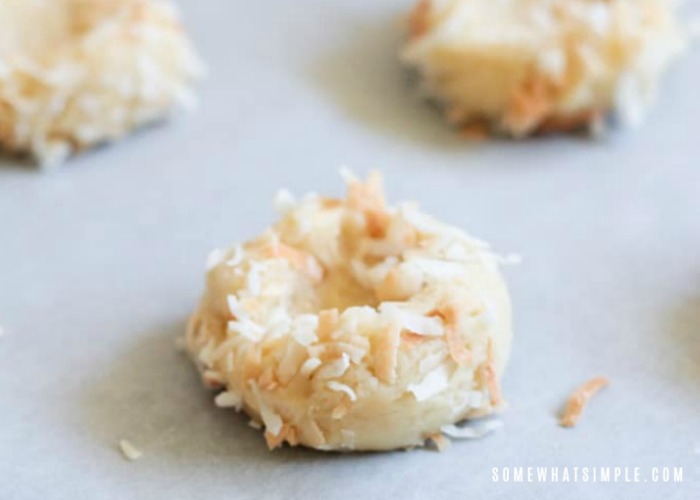three balls of raw cookie dough covered with shredded coconut that will make the cookies look like a bird's nest once they are fully cooked.