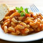 a plate of chili mac and a slice of bread