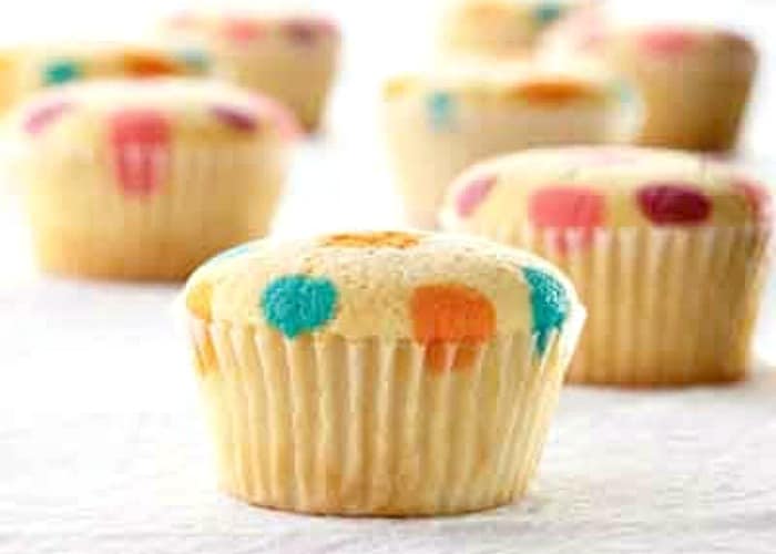 vanilla cupcakes with orange blue yellow red and purple polka dots