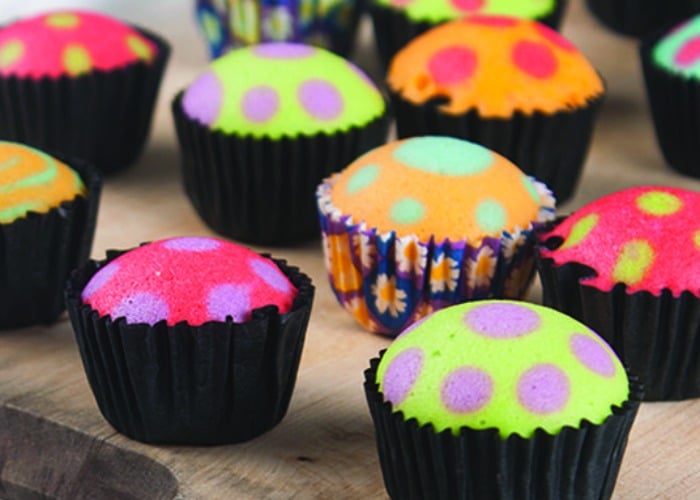 bright pastel colored cupcakes with brightly colored polka dots and black liners