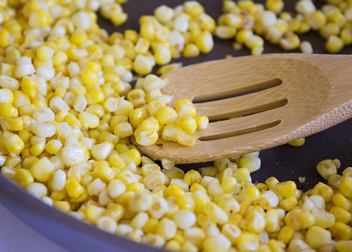 kernels of corn cooking in a frying pan