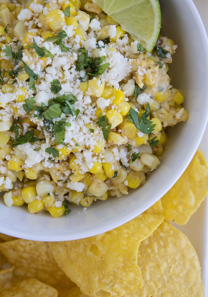 looking down on a bowl of Mexican Corn Salad with a slice of lime on top