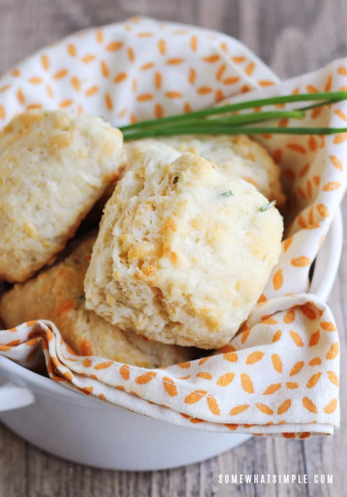 looking down on a bowl filled with cheddar biscuits topped with chives