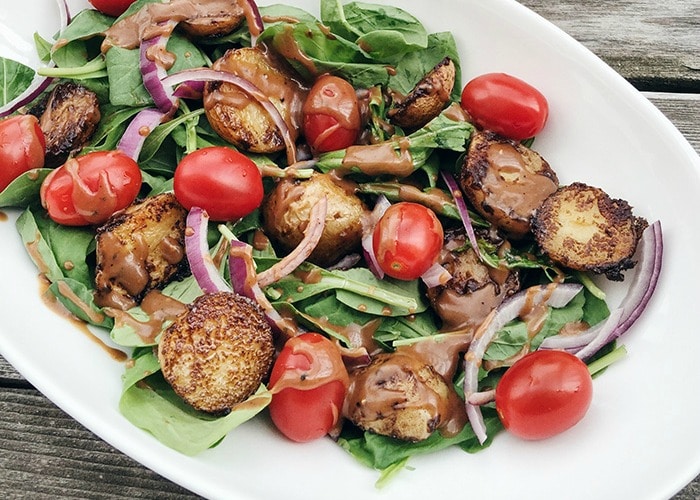 a potato arugula salad with a vinaigrette dressing