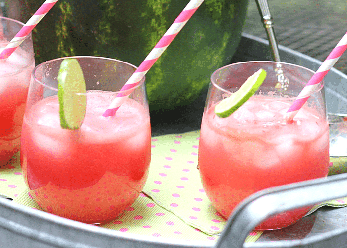 three glasses of Watermelon Punch on a serving tray with a watermelon bowl in the background